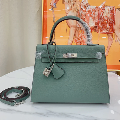 Muted Forest Green Contrast Handle Compact Rectangular Hand Bag With Sleek Silvery Twist Lock Hardware And Fine Defined Grain Detailing