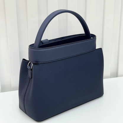 Deep Navy Blue Curved Structured Handbag With Geometric Pyramid Trim Accents And Rounded Smooth Top Carry Handle