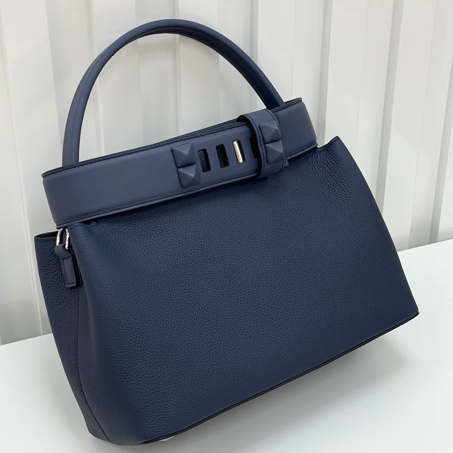 Deep Navy Blue Curved Structured Handbag With Geometric Pyramid Trim Accents And Rounded Smooth Top Carry Handle