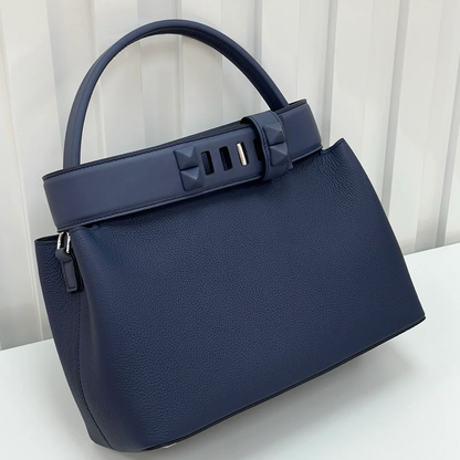 Deep Navy Blue Curved Structured Handbag With Geometric Pyramid Trim Accents And Rounded Smooth Top Carry Handle
